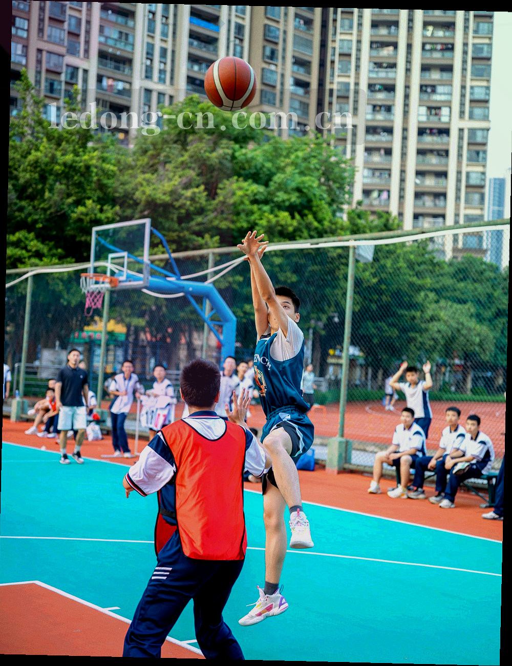 灯光训练场上青少年球员折返跑的逆光剪影
